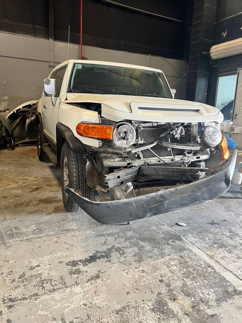 A car with significant front-end damage before repair.