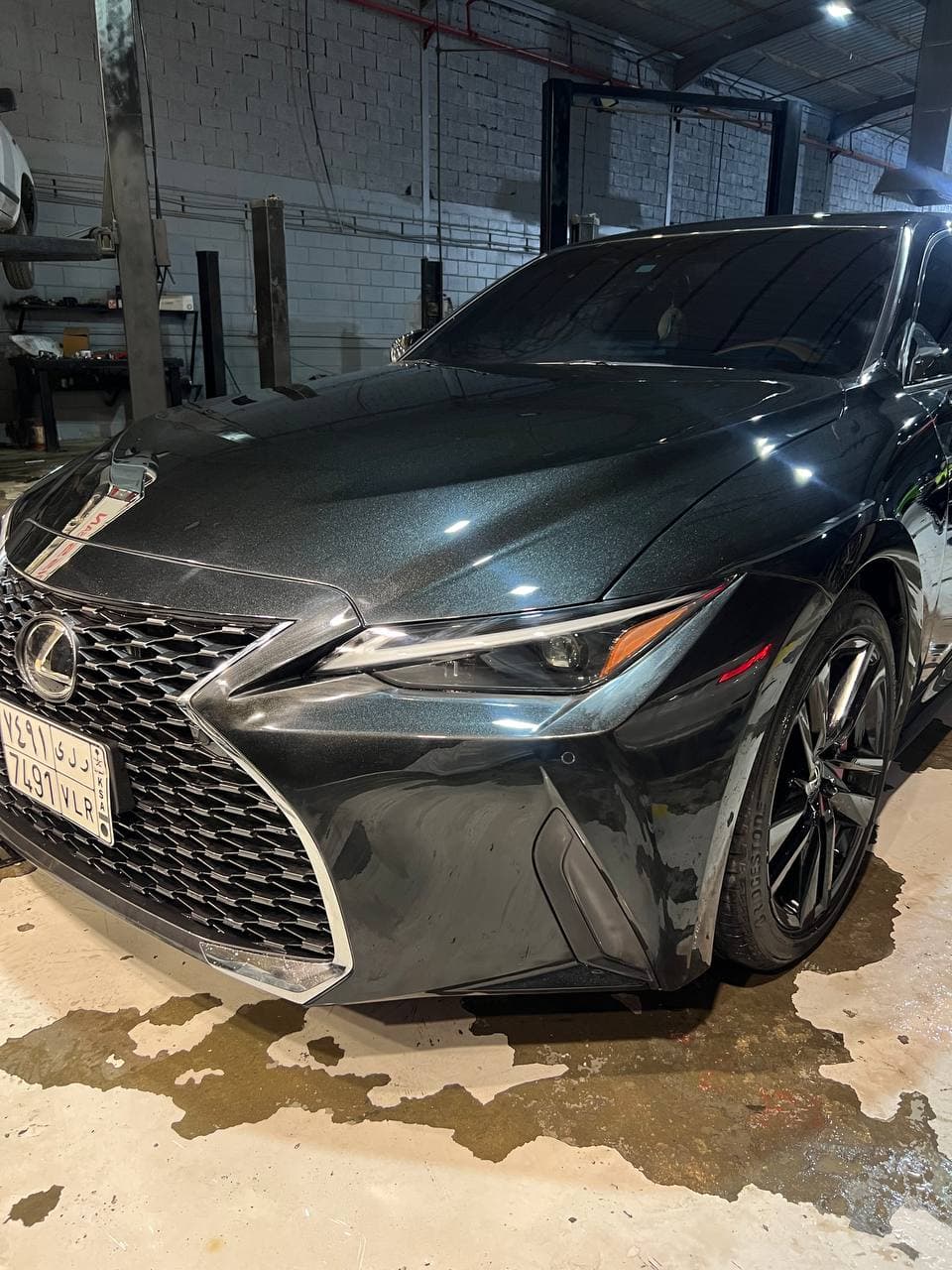 A shiny black car looking brand new after repairs.